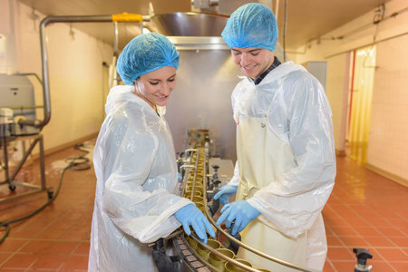 Factory workers stood either side of conveyor