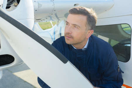 Mechanic looking at aircraft propellorの写真素材
