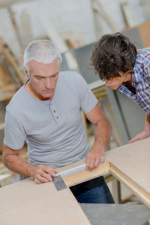 Carpenter training apprentice, using T Squareの写真素材