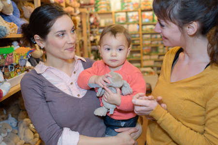 mother and daughter with attractive vendor in toy storeの写真素材