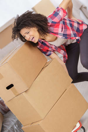 woman with backache while lifting boxの写真素材
