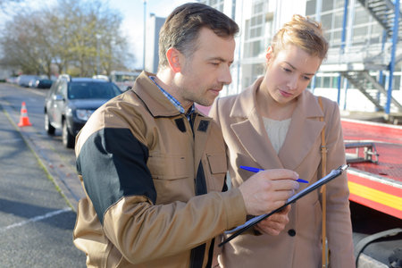 Recovery man filling out form with ladyの写真素材