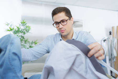 close up of businessman packing clothes into travel bagの写真素材