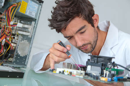 Computer repairman using screwdriverの写真素材