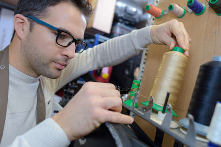 threading cotton on a machineの写真素材
