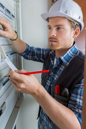 young electrician working on electric panel