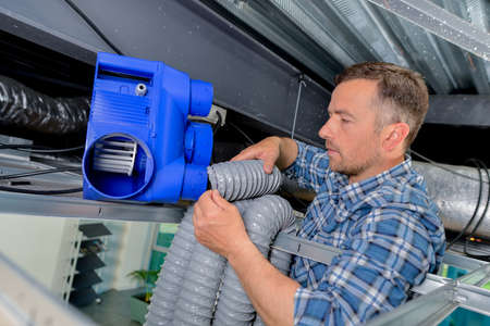 Labourer assembling a forced ventilationの写真素材