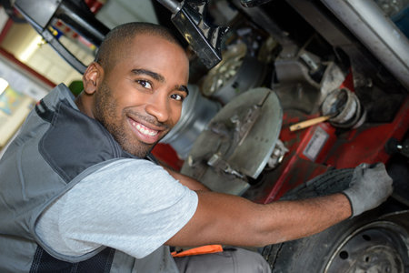 mechanic posing in front of a car