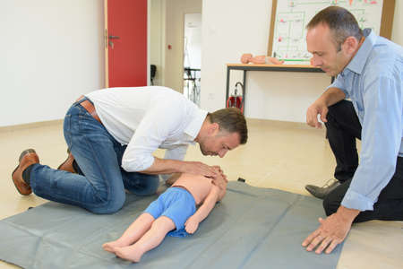 Man practicing resuscitation on a child dummyの写真素材