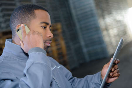 warehousing worker using tab and smartphoneの写真素材