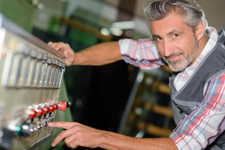 Portrait of man pressing button on machineの写真素材