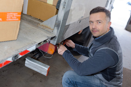 young delivery man with loading boxes in truck