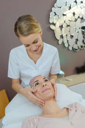Beautician giving head massageの写真素材