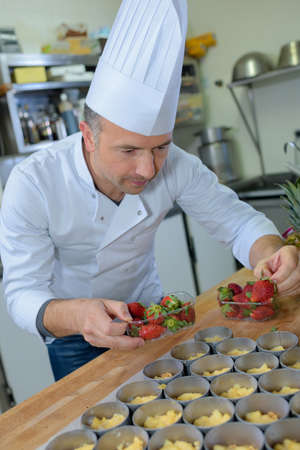 Chef making strawberry tartsの写真素材