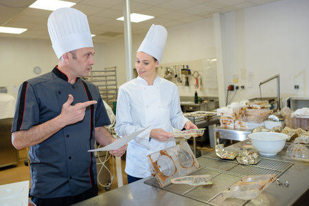 portrait of two chefs in cook uniform in the kitchen