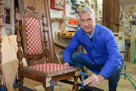 older man restoring a chairの写真素材