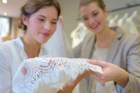 Women looking at lace of wedding dressの写真素材