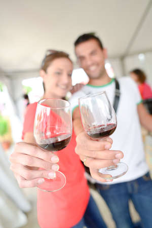 Couple holding up glasses of wineの写真素材