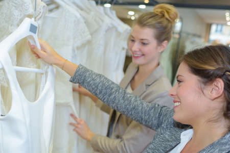 Women looking at bridal gownsの写真素材