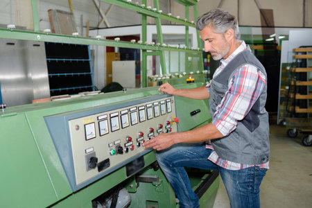 Mature man operating industrial machineの写真素材