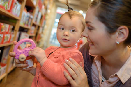 young mother her daughter shopping at the toy storeの写真素材