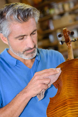 Man polishing string instrumentの写真素材