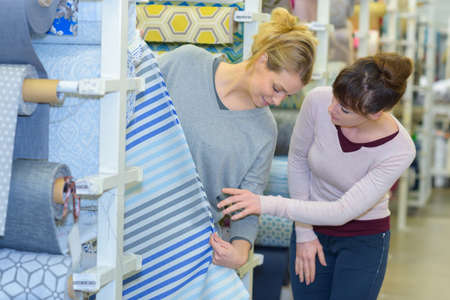 Women looking at material on rollの写真素材