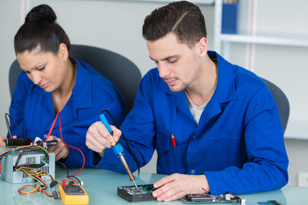 students in computing class fixing hardware