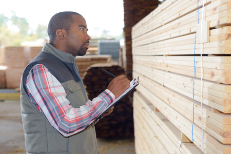 Man noting wood reference onto clipboard