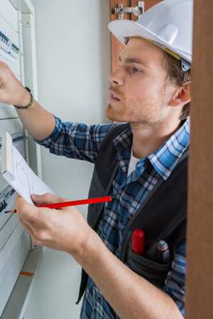 young electrician working on electric panel