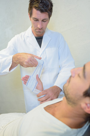 Medic bandaging man's handの写真素材