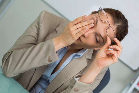 tired businesswoman having huge headacheの写真素材