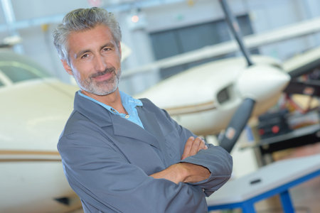 Portrait of middle aged man in aircraft hangar