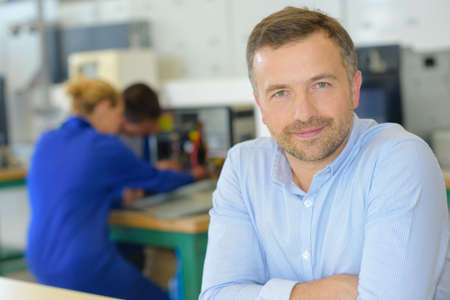 Portrait of teacher, students in backgroundの写真素材