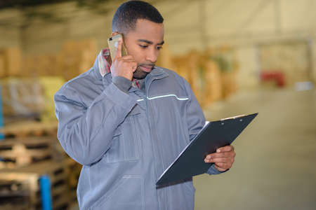 Warehouse worker using cellphoneの写真素材