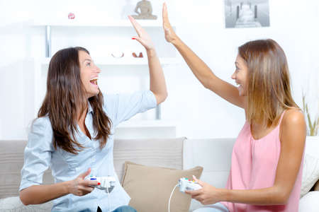 Two women having fun playing video gamesの写真素材