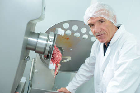 grinding meat using a machineryの写真素材