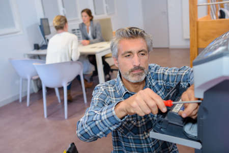 company handyman fixing a printerの写真素材