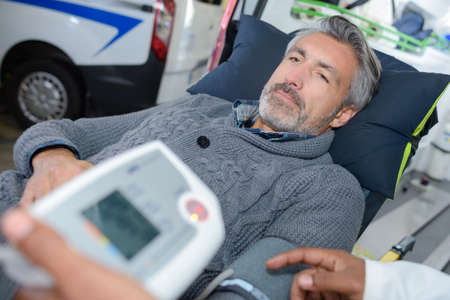 Man layed in stretcher have blood pressure testの写真素材
