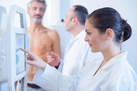 nurse taking scan of male patients abdomenの写真素材