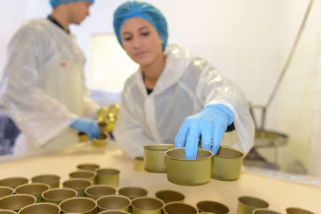 Factory worker preparing tin cansの写真素材