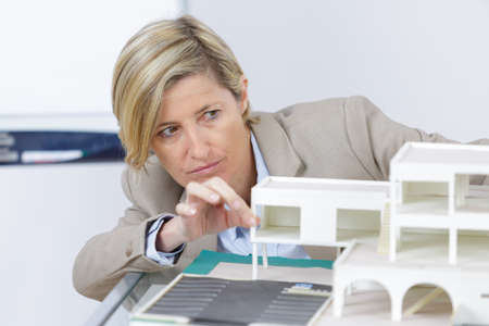 woman reviewing scale model of housesの写真素材