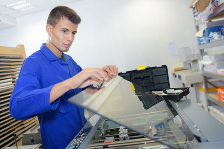Man lifting glass lid on machine