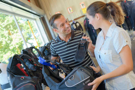 Couple indoors with golf bagsの写真素材