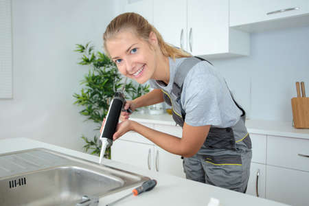 Woman using caulking gunの写真素材