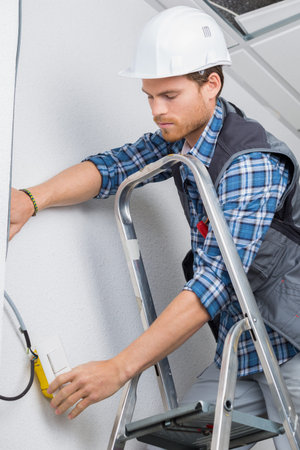 electrical worker wiring in ceilingの写真素材