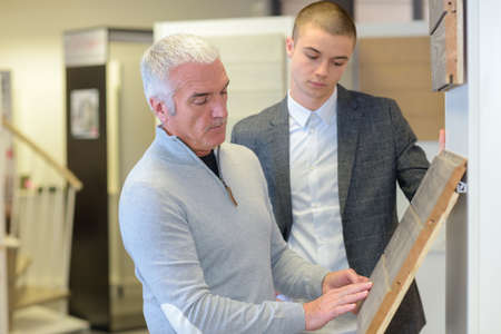 client choosing parquet flooring from different samples with sales representativeの写真素材