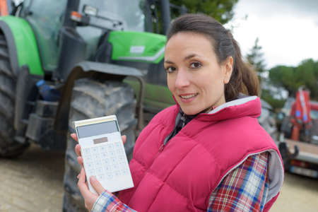 portrait of a tractor seller holding a calculatorの写真素材