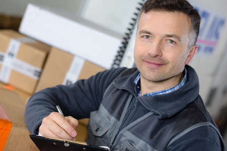 delivery man with parcel near cargo truck shipping serviceの写真素材