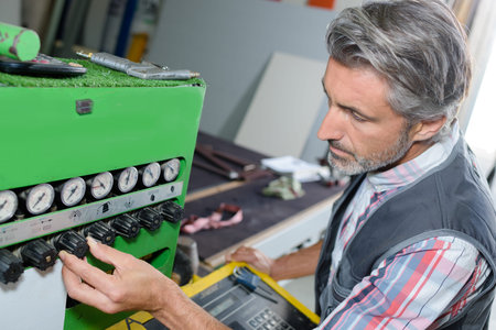 Man adjusting controls on industrial machine
